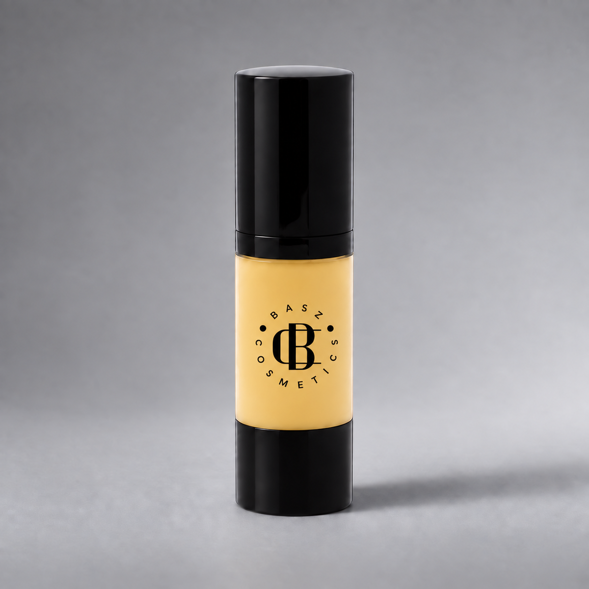 BaszCosmetics Bare It All Liquid Foundation — Golden Touch — Gold Adjuster (GA), black logo on gray studio background